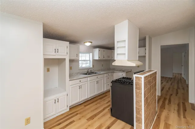 a kitchen with granite countertop a sink stove and refrigerator