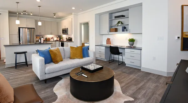 a living room with furniture and a dining table with wooden floor