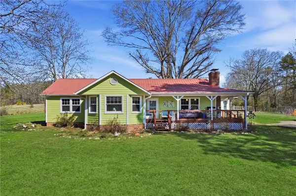 a front view of a house with garden and trees