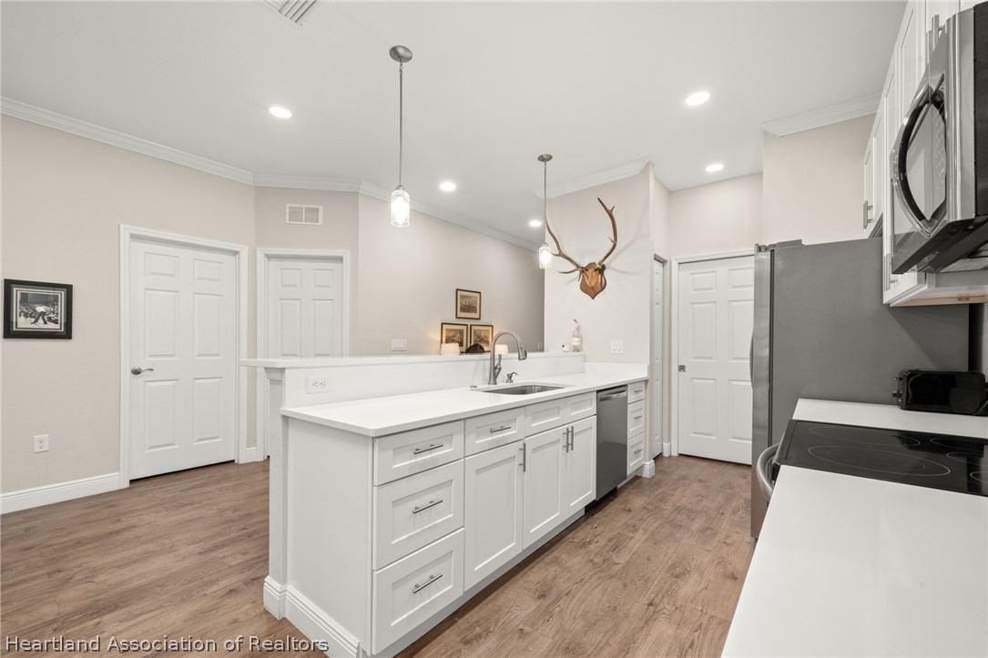 4734 Haw Branch Road, Unit 110 Sebring, FL 33875 - Photo 12 of 50 a kitchen with a sink a stove a refrigerator and cabinets