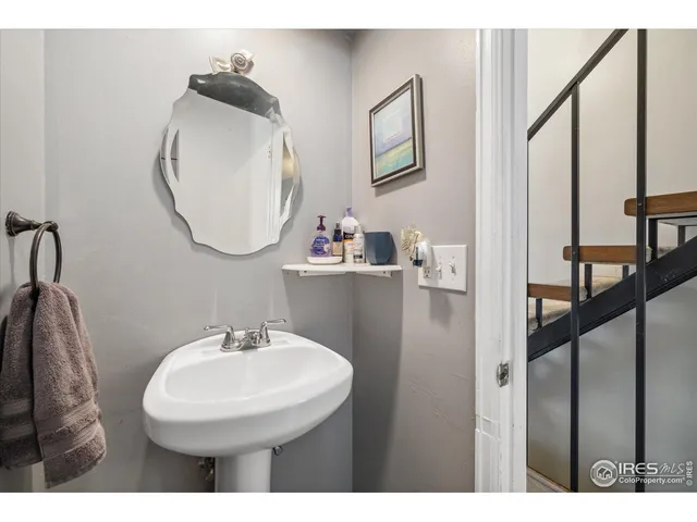 a view of staircase with lots of frames on wall and a window