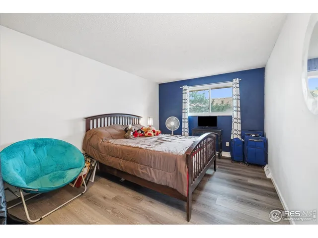 a bedroom with a bed a dresser and potted plants