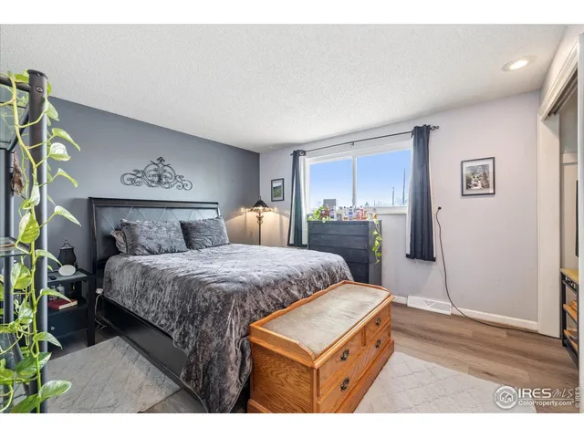a bedroom with a bed and a dresser with wooden floor