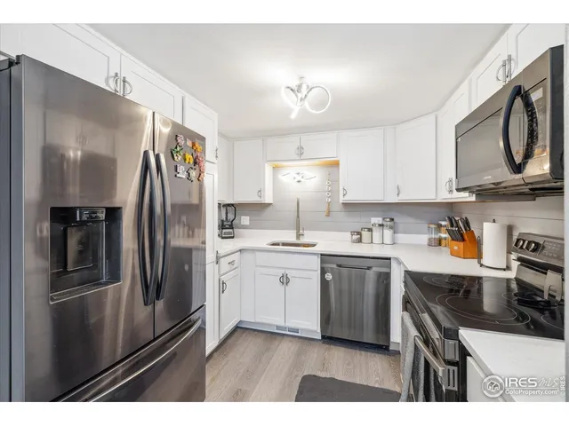 a kitchen with stainless steel appliances granite countertop a refrigerator a stove top oven a sink and dishwasher