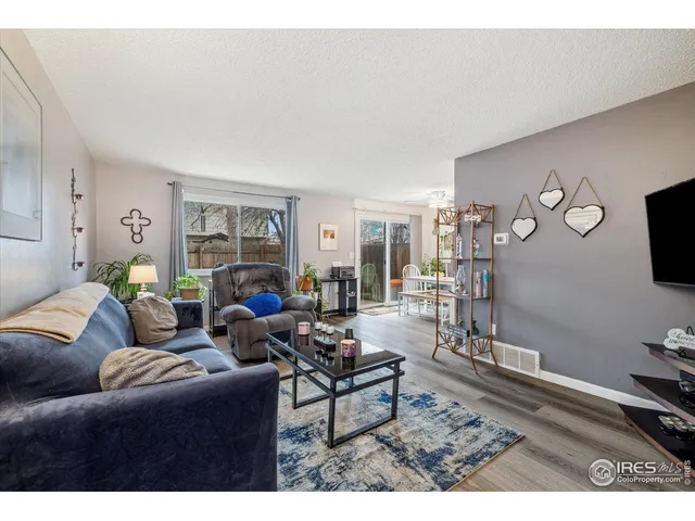 a living room with furniture a rug and a large window