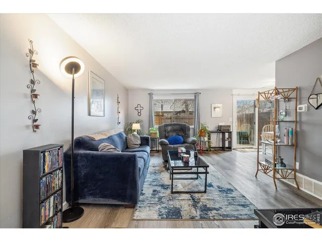 a living room with furniture a flat screen tv and a table