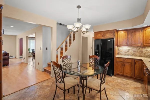 a dining room filled chandelier and wooden floor