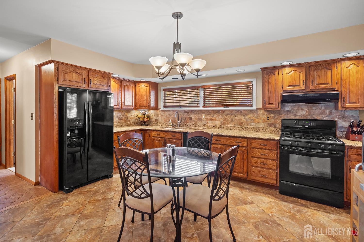 131 Woodland Road Piscataway, NJ 08854 - Photo 23 of 40 a kitchen with stainless steel appliances granite countertop a refrigerator a stove a oven a sink dishwasher with a dining table and chairs