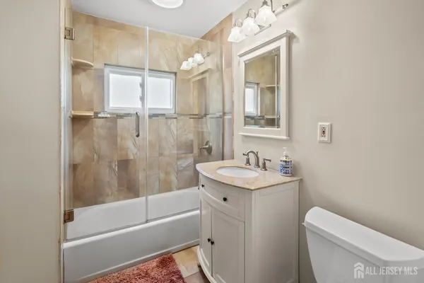 a bathroom with a granite countertop sink a toilet and shower