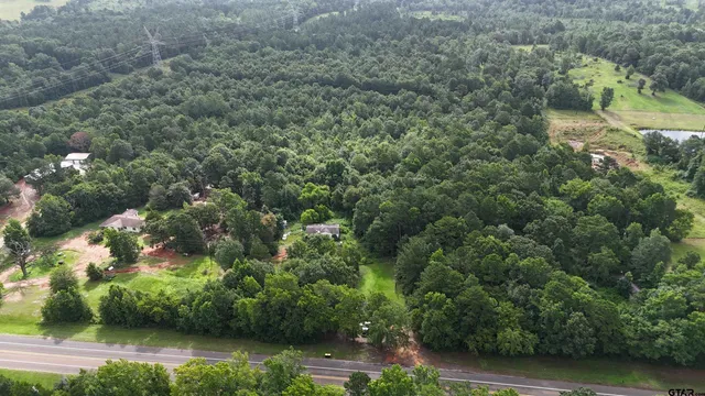 an aerial view of residential house with outdoor space and trees all around