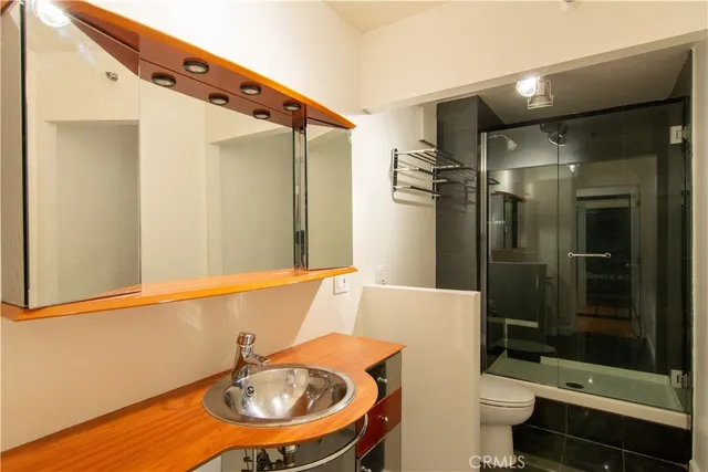 a bathroom with a sink a toilet and shower