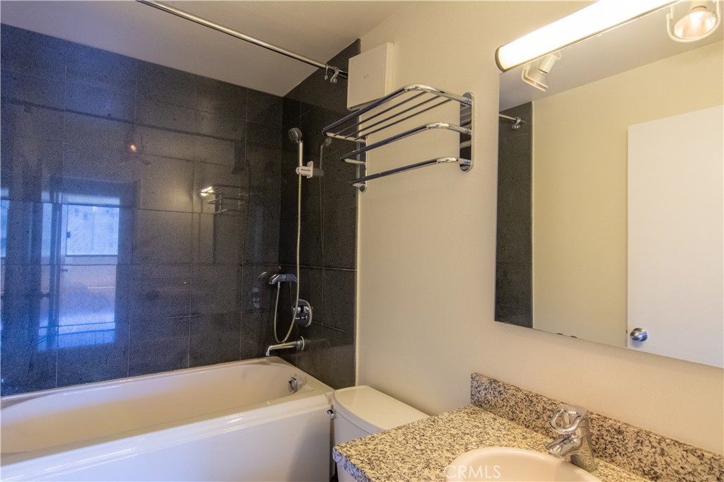 600 West 9th Street, Unit 1114 Los Angeles, CA 90015 - Photo 17 of 27 a bathroom with a granite countertop bathtub shower and toilet
