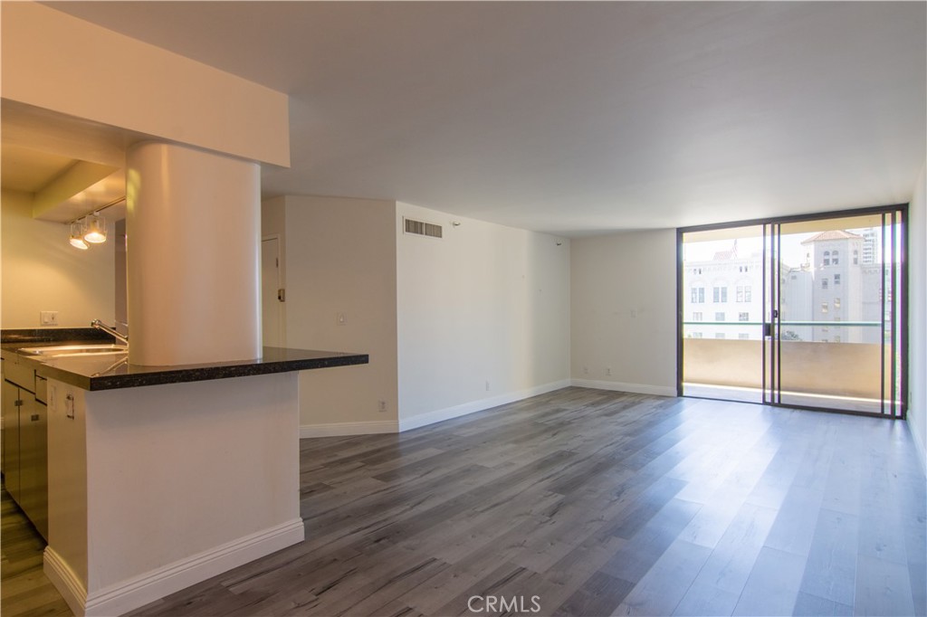 600 West 9th Street, Unit 1114 Los Angeles, CA 90015 - Photo 4 of 27 a view of an empty room with wooden floor and a window