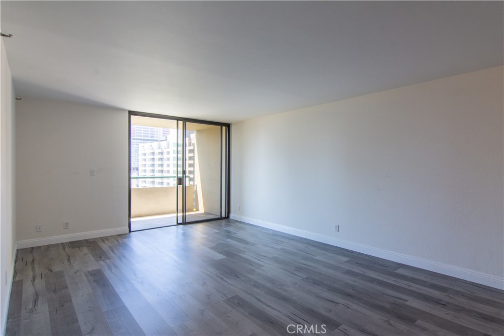 600 West 9th Street, Unit 1114 Los Angeles, CA 90015 - Photo 5 of 27 a view of an empty room with wooden floor and a window