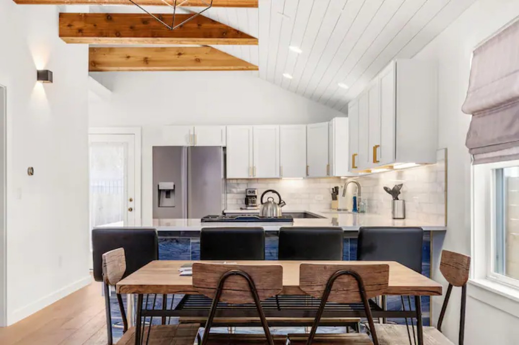 2319 Santa Rita Street Austin, TX 78702 - Photo 2 of 26 Kitchen featuring a peninsula, stainless steel fridge, white cabinetry, tasteful backsplash, and vaulted ceiling
