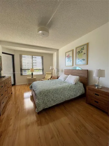 a bedroom with a large bed and a wooden floor