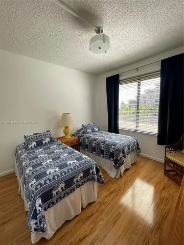 a bedroom with double bed and a flat tv screen on the dresser