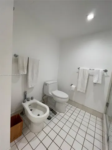 a white toilet sitting next to a bathroom sink and vanity