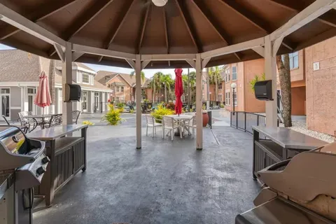 a view of a patio with table and chairs under an umbrella