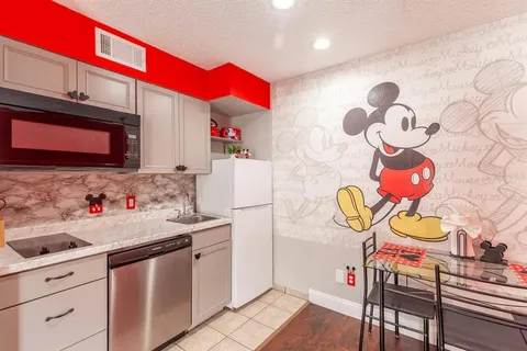 a kitchen with a sink a stove and wooden cabinets