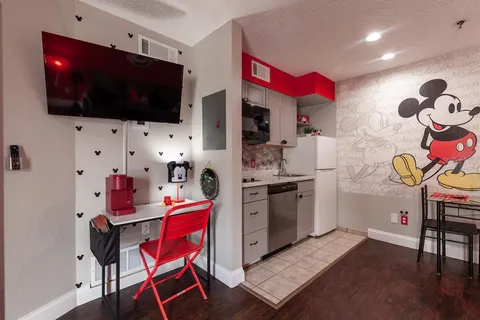 a living room with stainless steel appliances kitchen island granite countertop furniture and a flat screen tv
