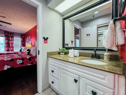 a bathroom with a granite countertop sink a large mirror and vanity