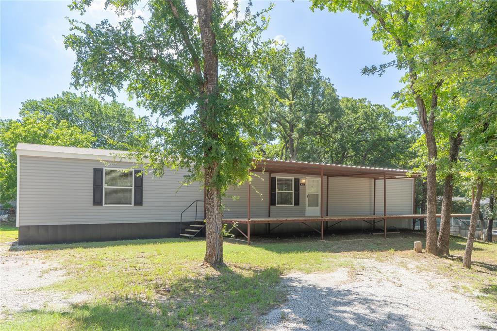 60 Tecumseh Road Valley View, TX 76272 - Photo 2 of 20 Light gray siding exterior with black shutters, featuring a covered porch extending the length of the home