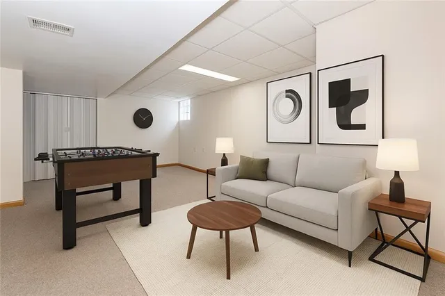 a living room with furniture a rug and a lamp