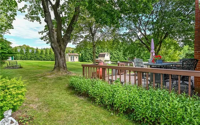 a view of a house with backyard and a trees