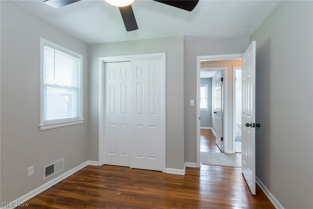 13175 McCracken Road Cleveland, OH 44125 - Photo 18 of 48 Bedroom with a closet, ceiling fan, multiple windows, and dark wood-type flooring