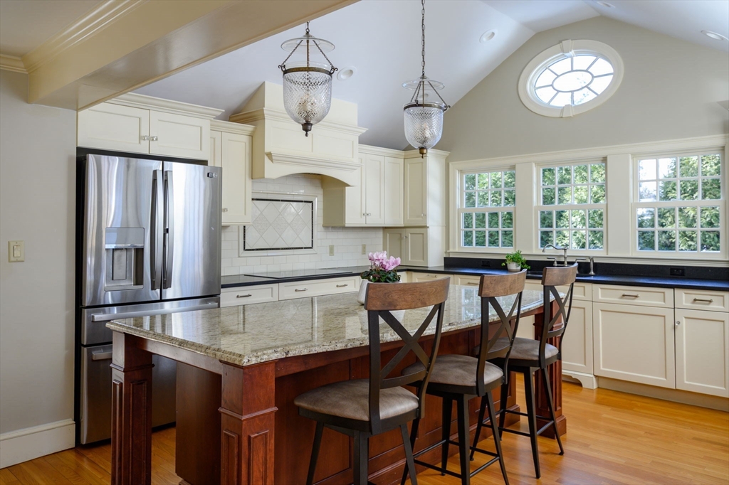 7 Village Lane Hingham, MA 02043 - Photo 3 of 34 a kitchen with stainless steel appliances granite countertop a table chairs stove and refrigerator
