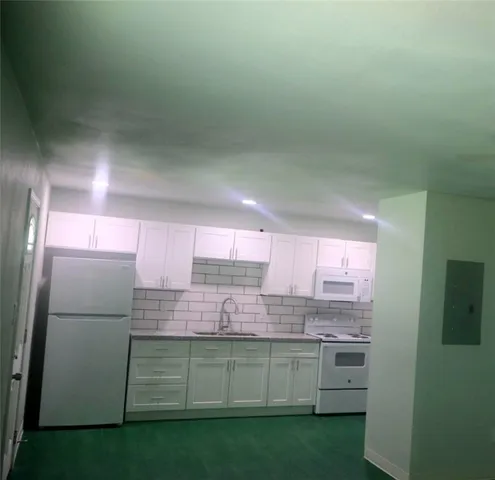 a kitchen with kitchen island granite countertop cabinets and refrigerator
