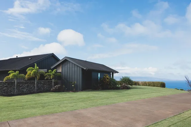 a front view of a house with a garden and yard