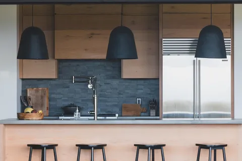 a kitchen with stainless steel appliances granite countertop a sink a stove and chairs with wooden floor