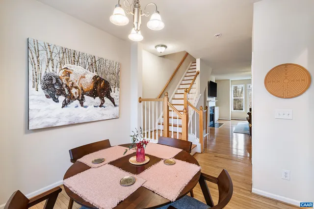 a view of a dining room with furniture a chandelier and wooden floor