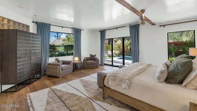 a bedroom with a bed couch and a large window