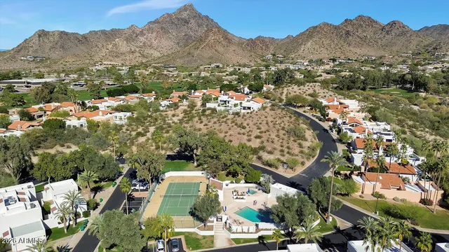 an aerial view of residential houses with outdoor space and trees