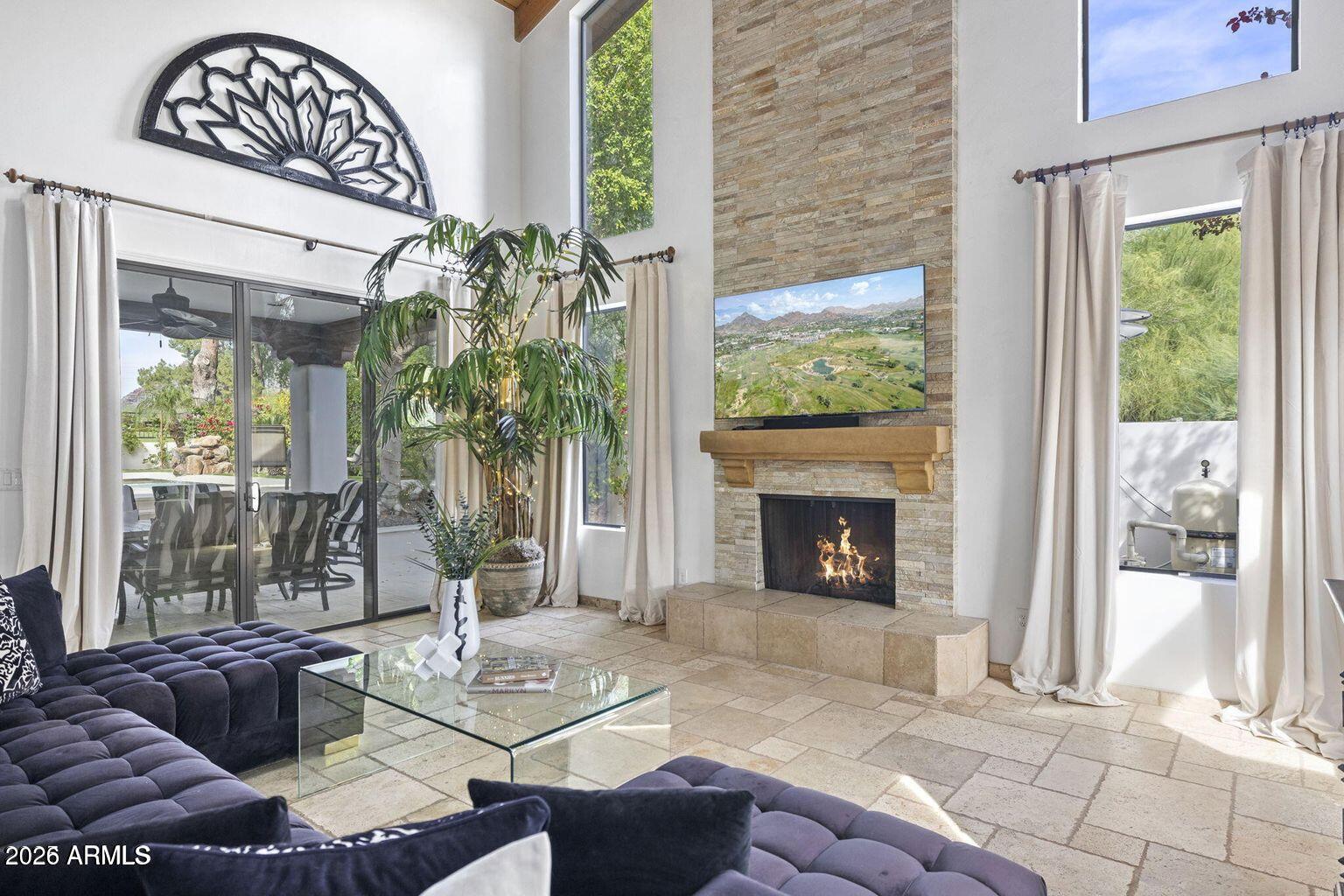 6198 North 28th Place Phoenix, AZ 85016 - Photo 5 of 21 a living room with furniture a fireplace and a floor to ceiling window