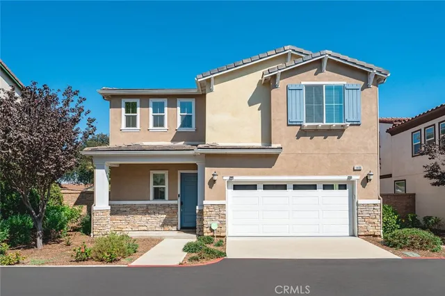 a front view of a house with a garden