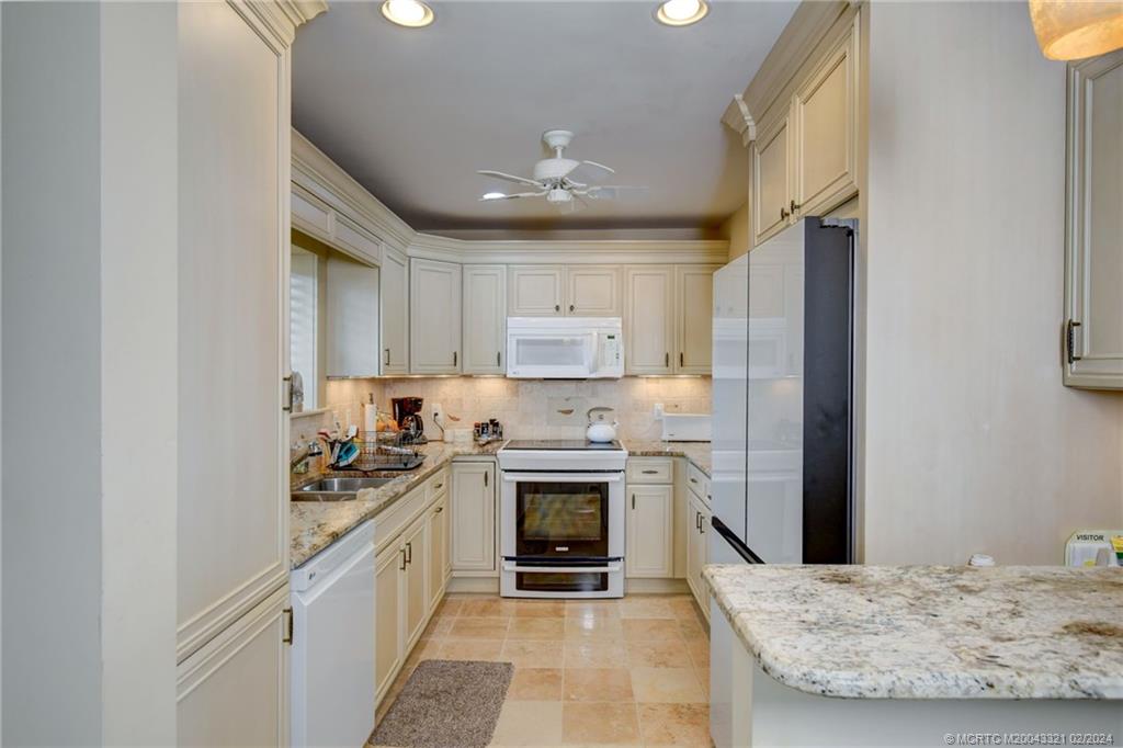 2375 Northeast Ocean Boulevard, Unit E405 Stuart, FL 34996 - Photo 16 of 58 a kitchen with stainless steel appliances granite countertop a stove sink and refrigerator