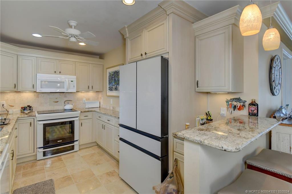 2375 Northeast Ocean Boulevard, Unit E405 Stuart, FL 34996 - Photo 17 of 58 a kitchen with granite countertop stainless steel appliances a stove sink and cabinets