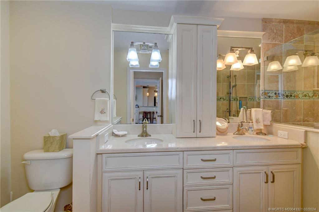 2375 Northeast Ocean Boulevard, Unit E405 Stuart, FL 34996 - Photo 22 of 58 a bathroom with a granite countertop sink a toilet and mirror