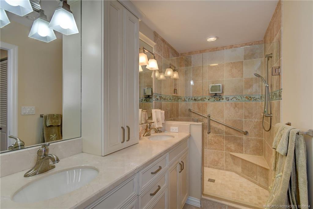 2375 Northeast Ocean Boulevard, Unit E405 Stuart, FL 34996 - Photo 23 of 58 a bathroom with a double vanity sink a mirror and a shower