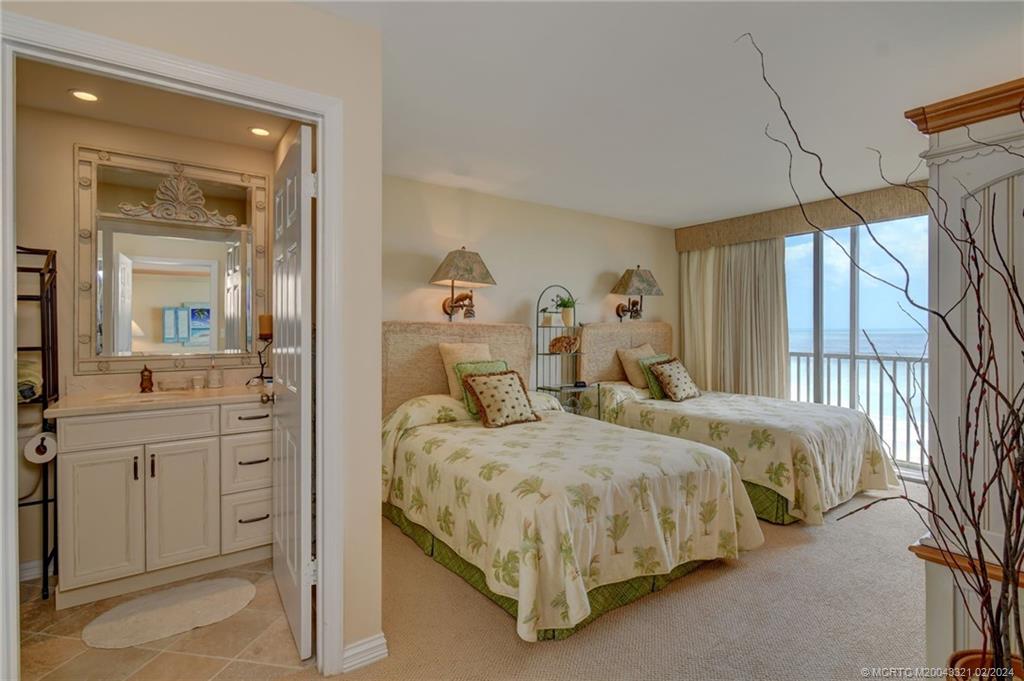 2375 Northeast Ocean Boulevard, Unit E405 Stuart, FL 34996 - Photo 24 of 58 a bedroom with two beds and large windows