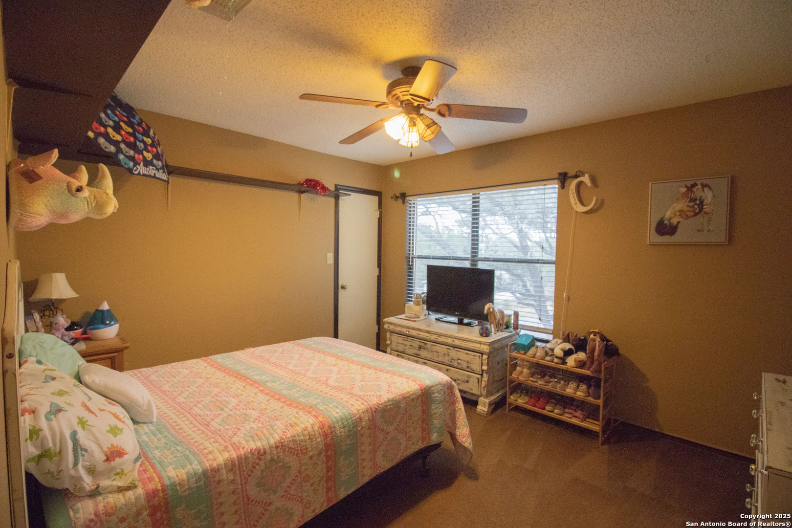 797 Killarney Road Floresville, TX 78114 - Photo 20 of 35 a bedroom with a bed and a chandelier