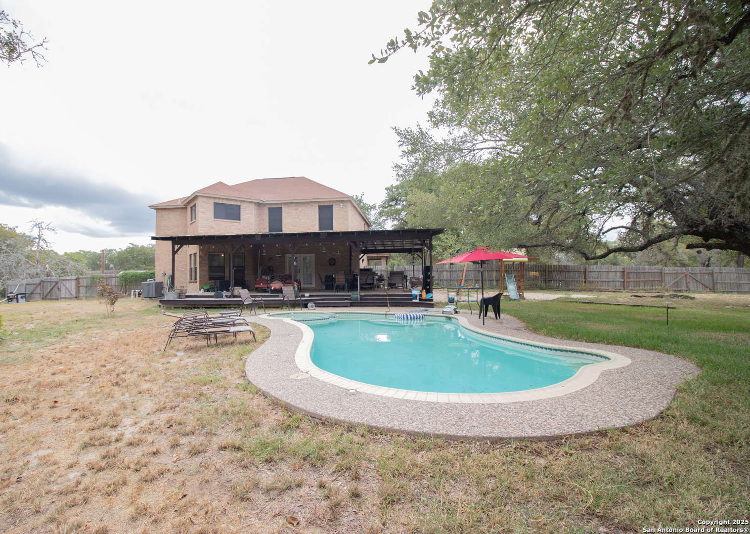 797 Killarney Road Floresville, TX 78114 - Photo 26 of 35 a view of a house with swimming pool and a yard