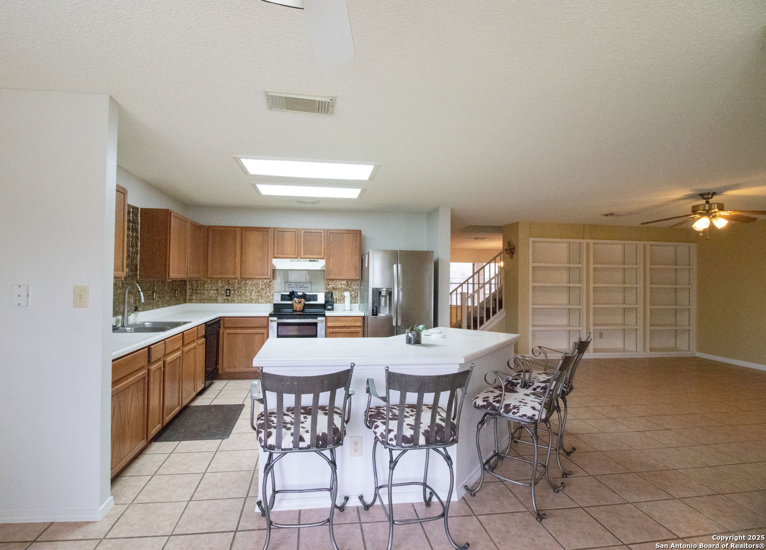 797 Killarney Road Floresville, TX 78114 - Photo 10 of 35 a large kitchen with granite countertop a dining table chairs and white cabinets