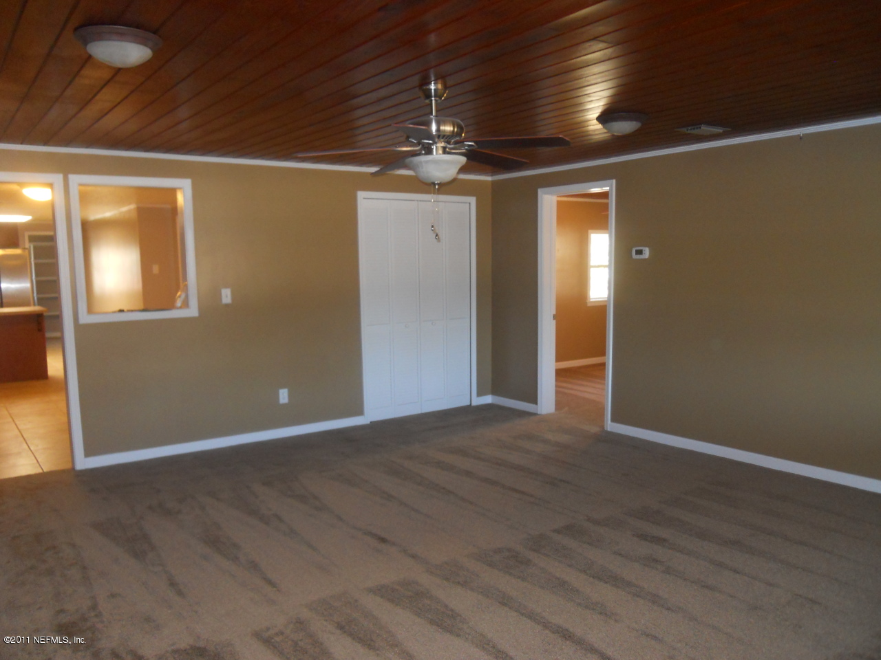 246 Alvis Road Jacksonville, FL 32220 - Photo 21 of 54 a view of an empty room with wooden floor and a ceiling fan