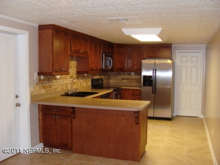 246 Alvis Road Jacksonville, FL 32220 - Photo 3 of 54 a kitchen with stainless steel appliances granite countertop a refrigerator a stove and a sink