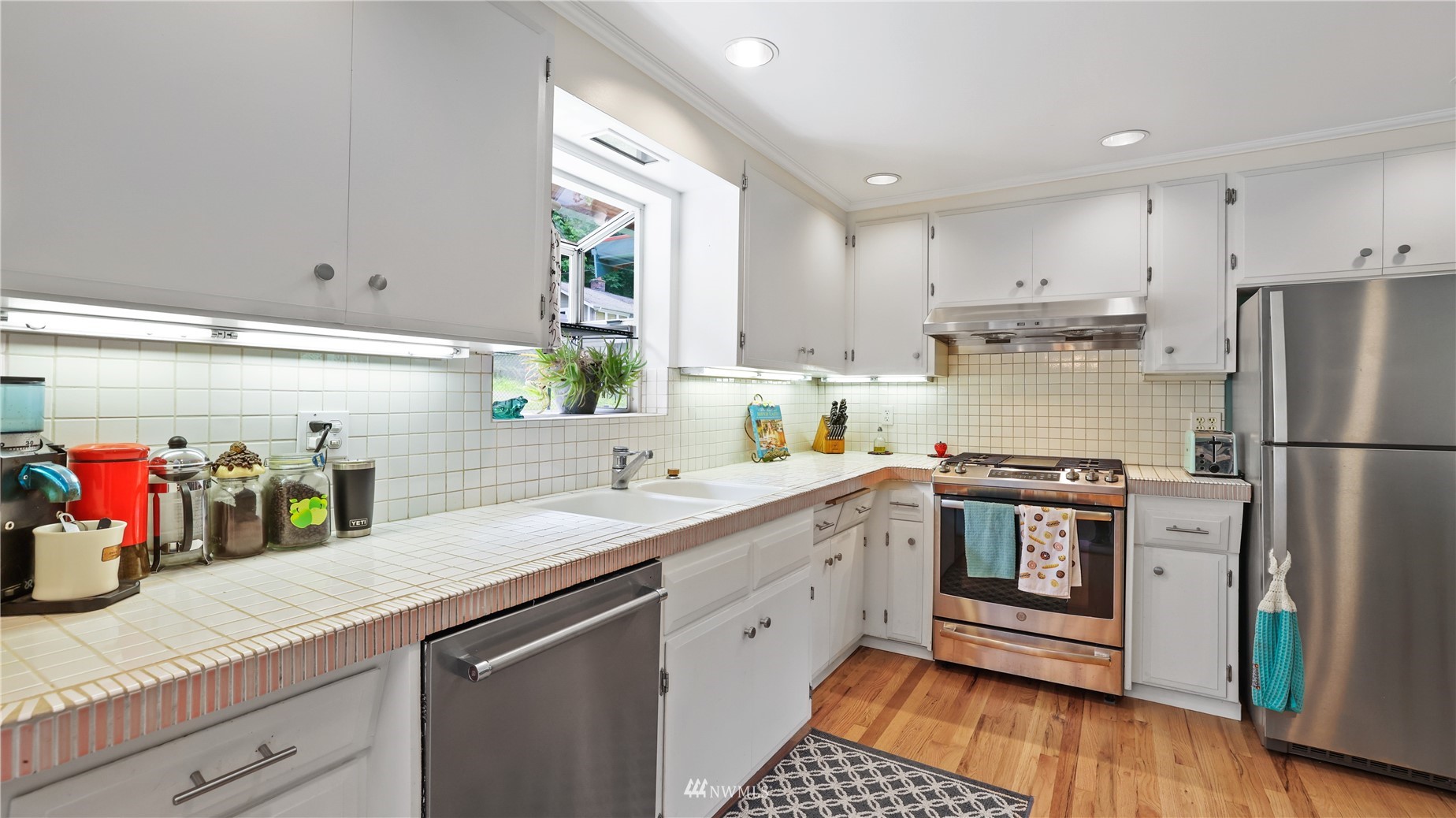 16819 Renton Issaquah Road Southeast Renton, WA 98059 - Photo 12 of 36 a kitchen with a sink cabinets stainless steel appliances and wooden floor